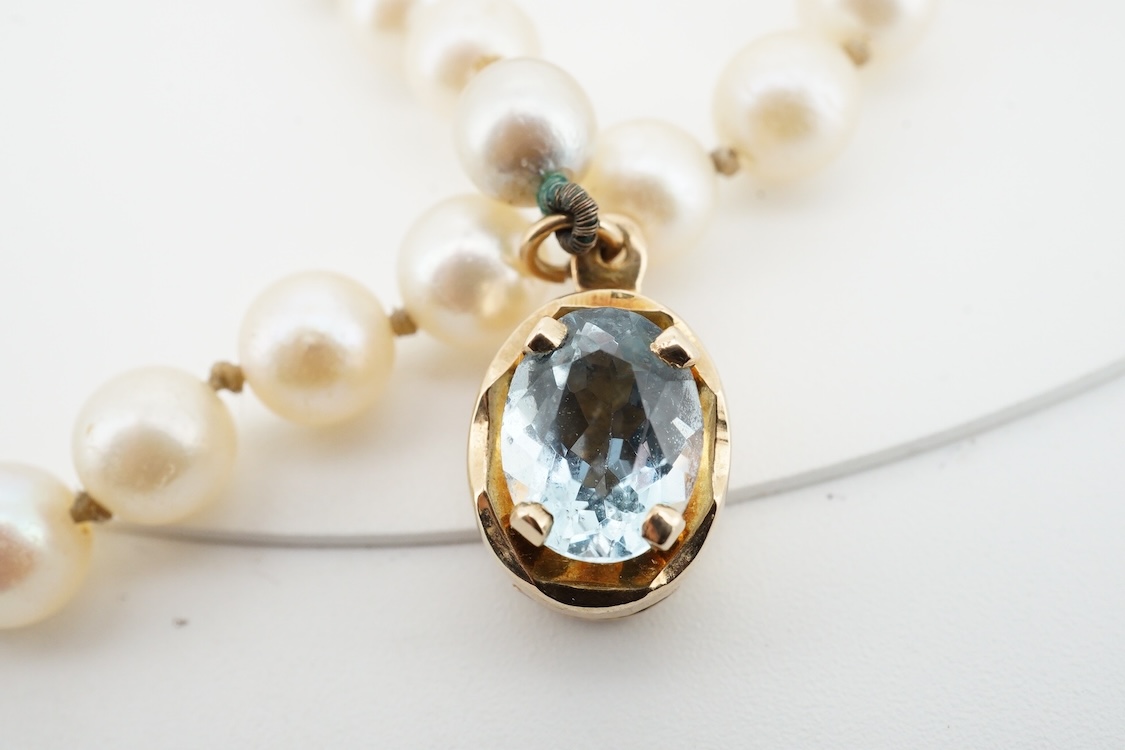A cultured pearl and aquamarine necklace, composed of a single strand of cultured pearls, to a gold clasp set with an oval aquamarine, length 53.5cm, Condition: in good condition, minor wear, minor variations in pearl co